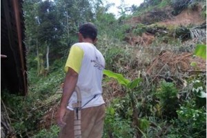 Warga Longkewang menunjukan lokasi yang ternena longsor.